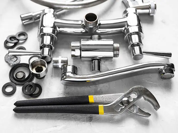 Polished chrome kitchend sink faucet disassembled with plumbing wrench