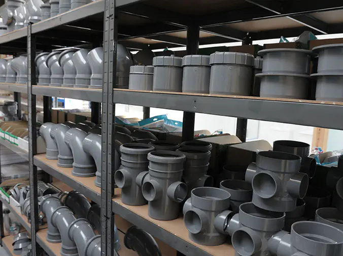 Large grey PCV pipe fittings in a plumbing warehouse