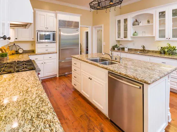 Kitchen with green stone countertops and stainless faucet and fixtures