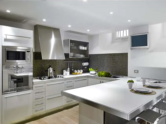Kitchen with white cabinets and a large stainless steel oven hood