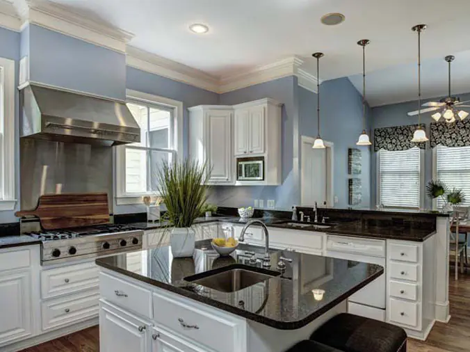 Large kitchen with black countertops and stainless faucets and fixtures