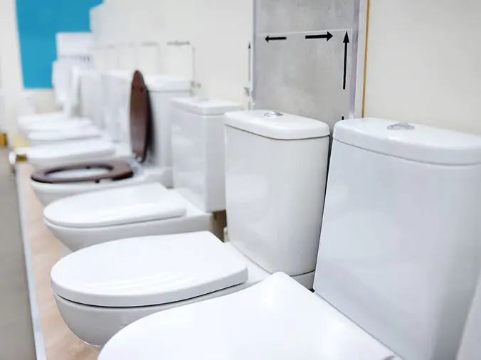 Toilest lined up in a plumbing supply store