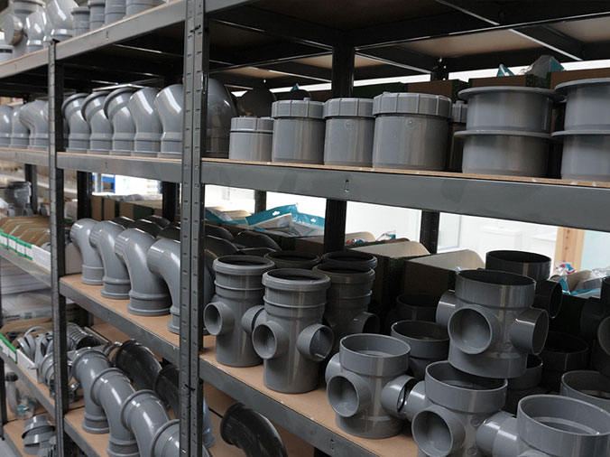 Large grey PCV pipe fittings in a plumbing warehouse